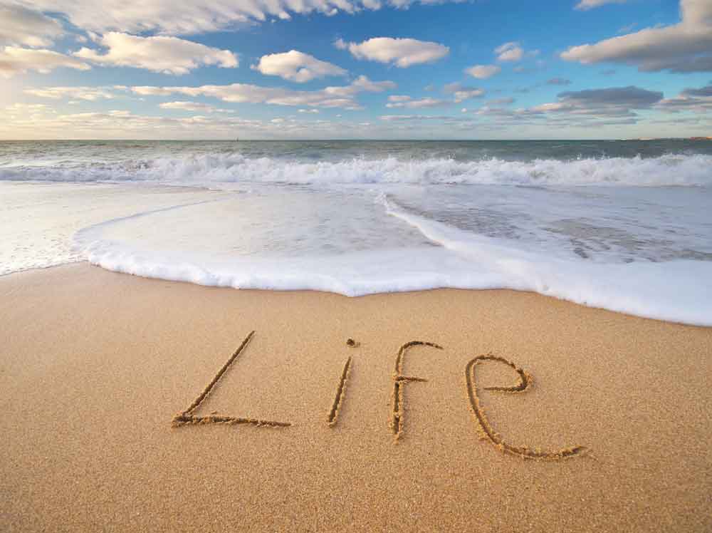 the word life being washed away in the sand