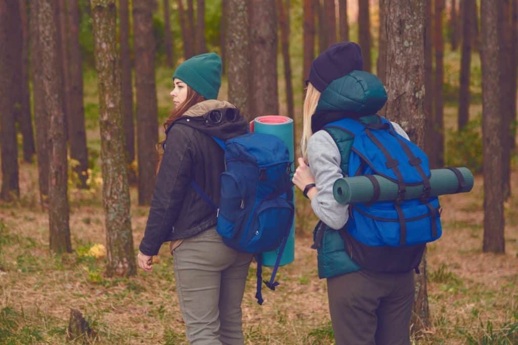 Female travelers with backpacks in the forest