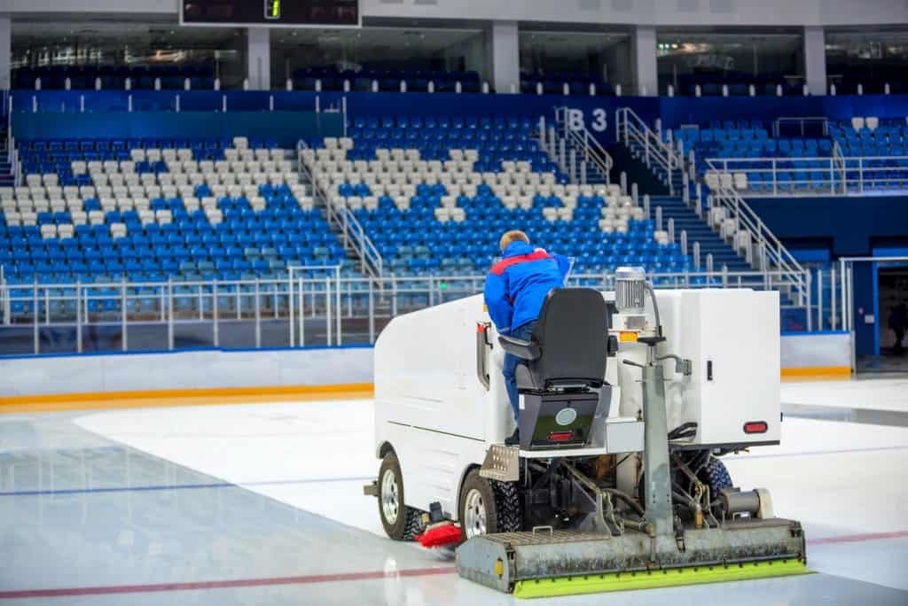 Resurfacing machine cleans ice of hockey rink